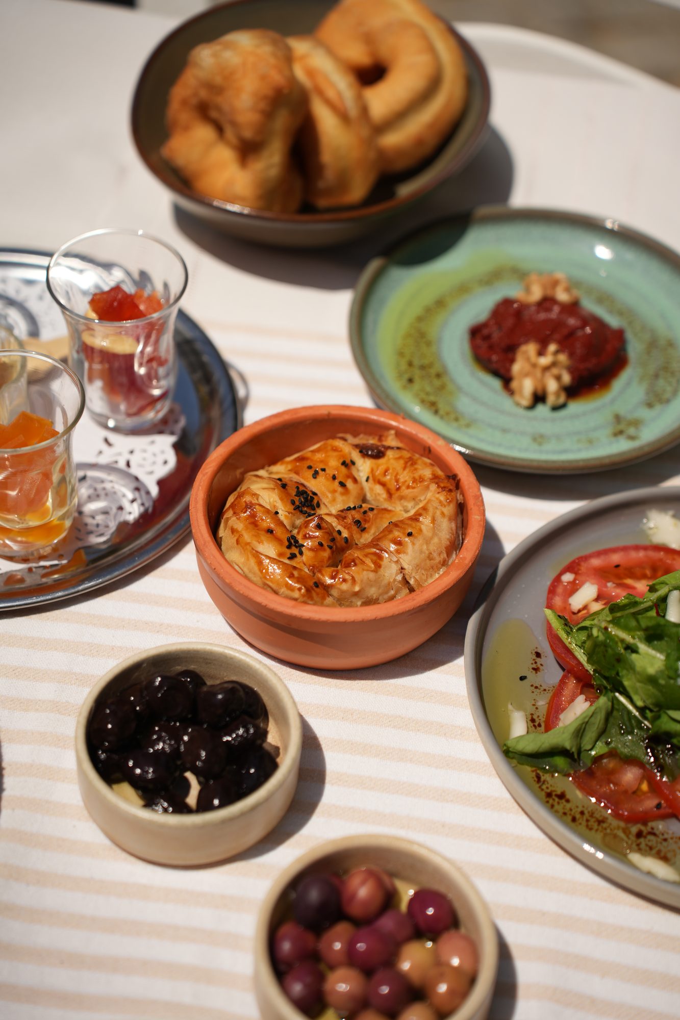 Serpme kahvaltı sofrası — su böreği, acuka, zeytin ve mevsim salatası
